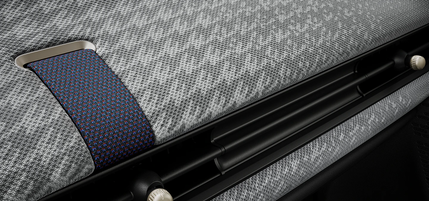 Vue rapprochée du tableau de bord façon tissu tricoté 2D à l’intérieur de la MINI Cooper.