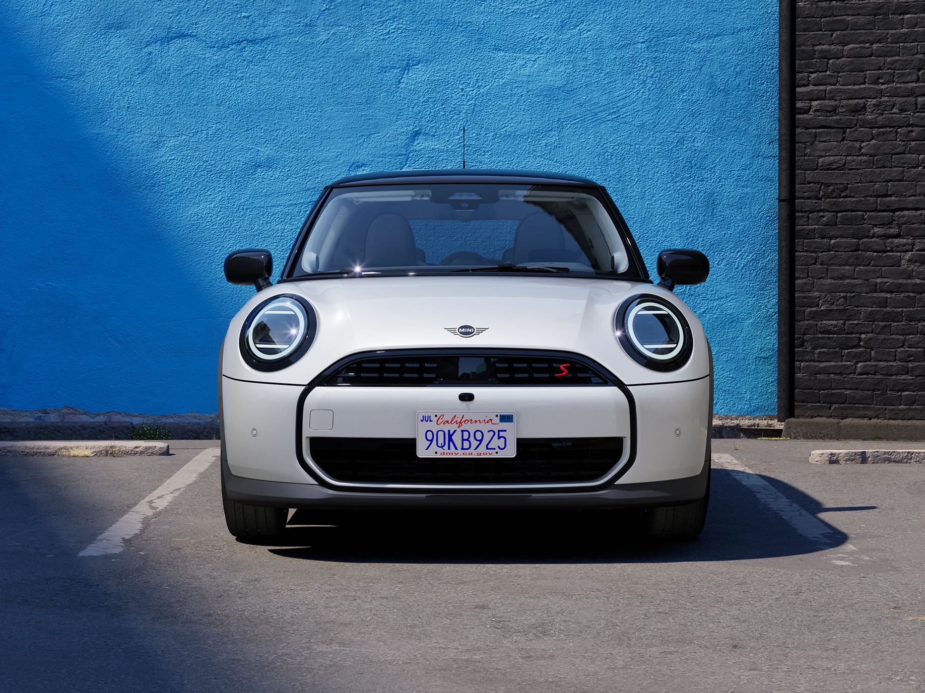 Vue avant de la MINI Cooper Nanuq White à toit noir en stationnement.