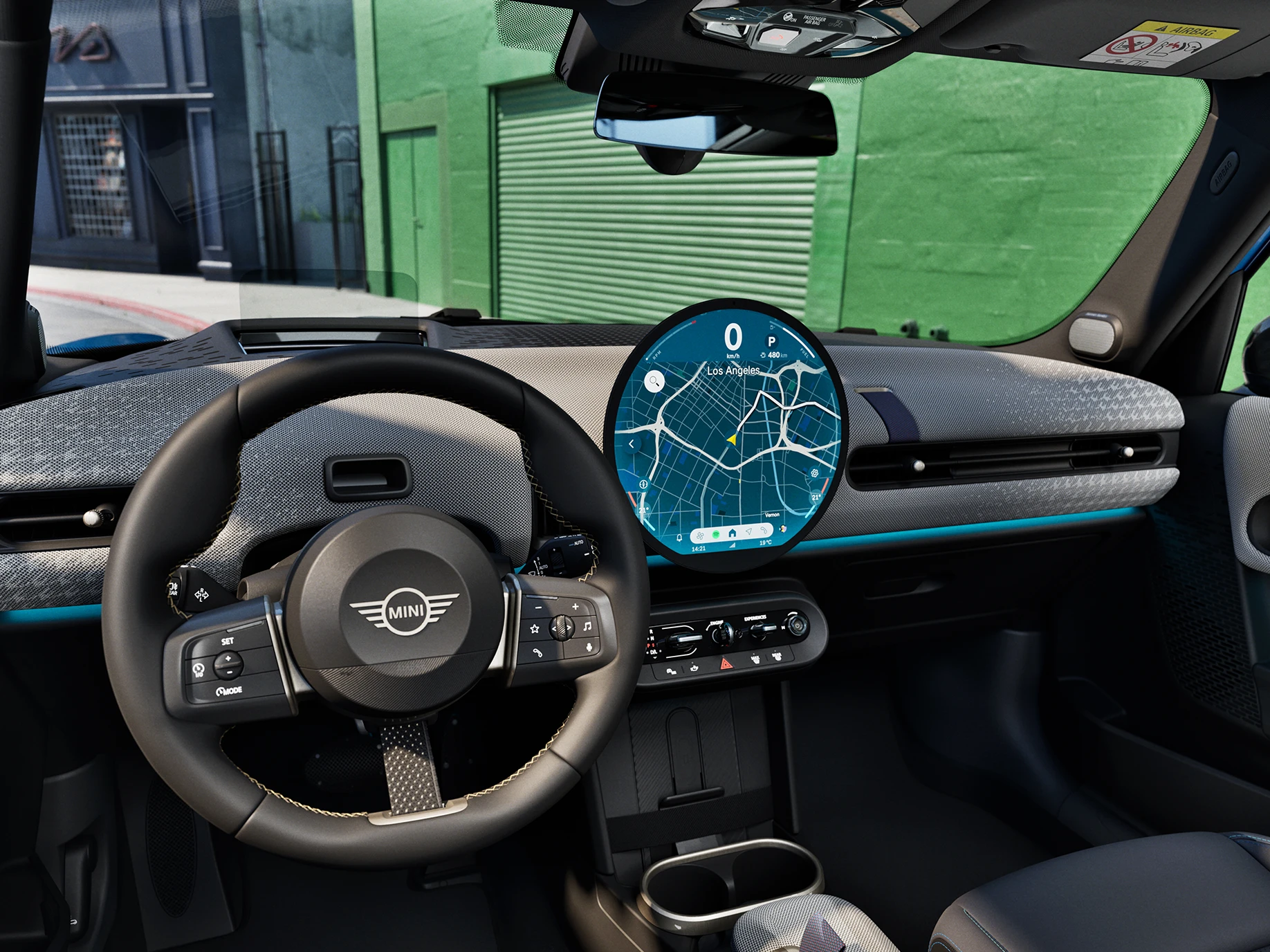 Vue de l’intérieur de la MINI Cooper 5 portes mettant l’accent sur le volant, le tableau de bord et l’unité d’interaction.
