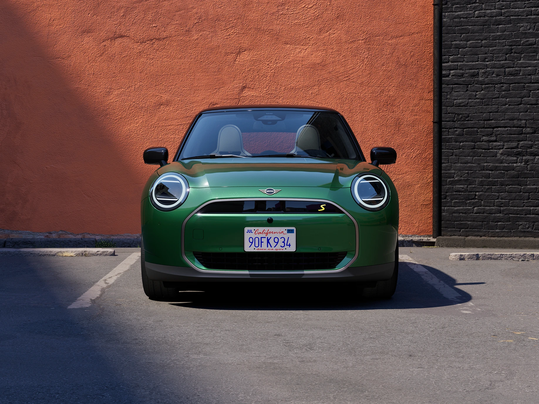 Vue avant d’une MINI Cooper Electric British Racing Green avec toit noir.