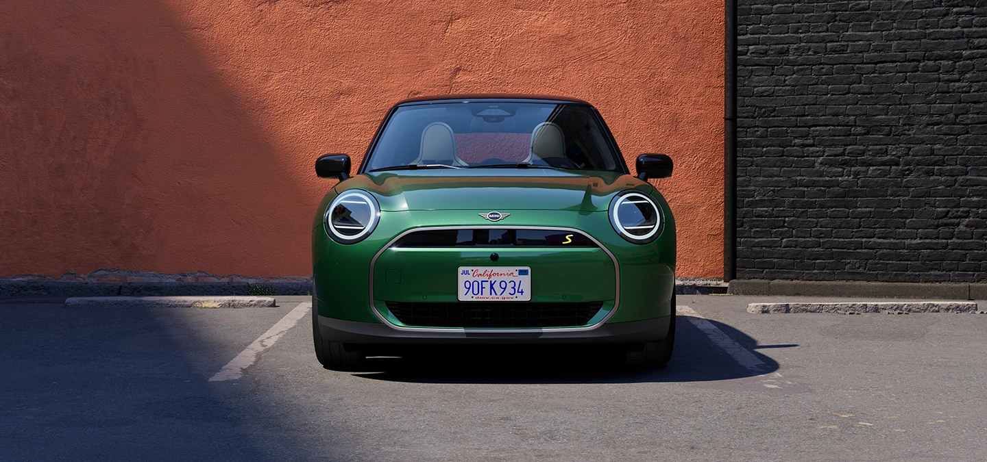 Vue avant d’une MINI Cooper Electric British Racing Green avec toit noir.