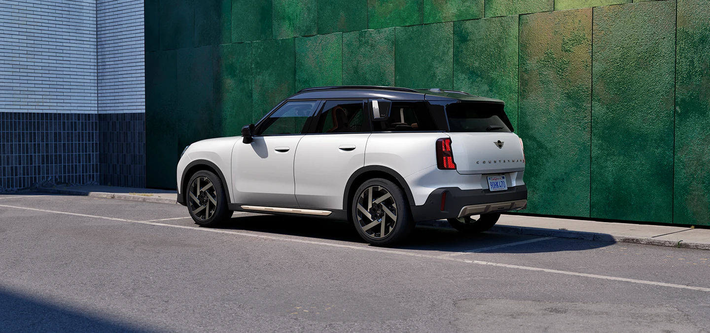 Vue arrière latérale du MINI Countryman Nanuq White avec toit noir stationné en ville.