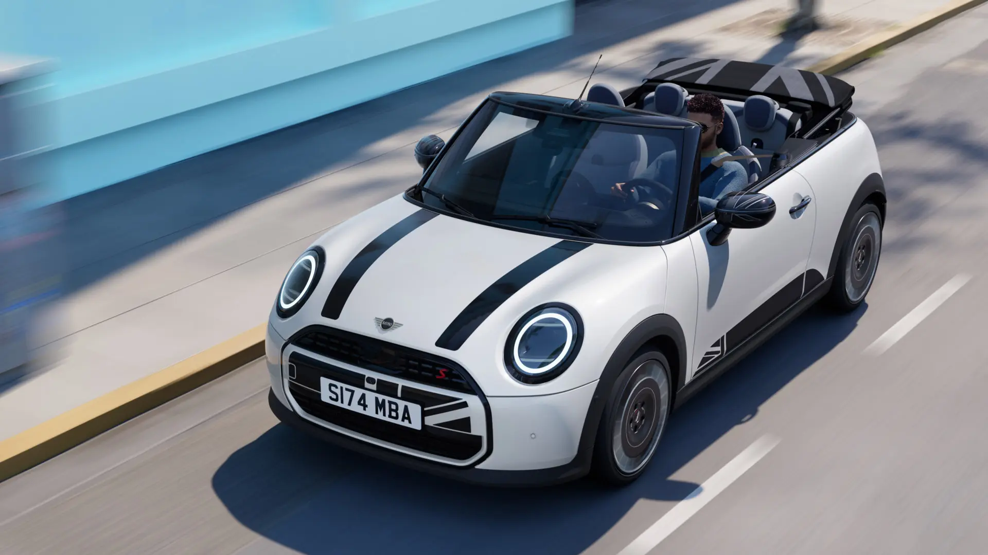 Vue aérienne d'une MINI Cabrio en Nanuq White avec des films autocollants noirs MINI Heritage sur le capot. 