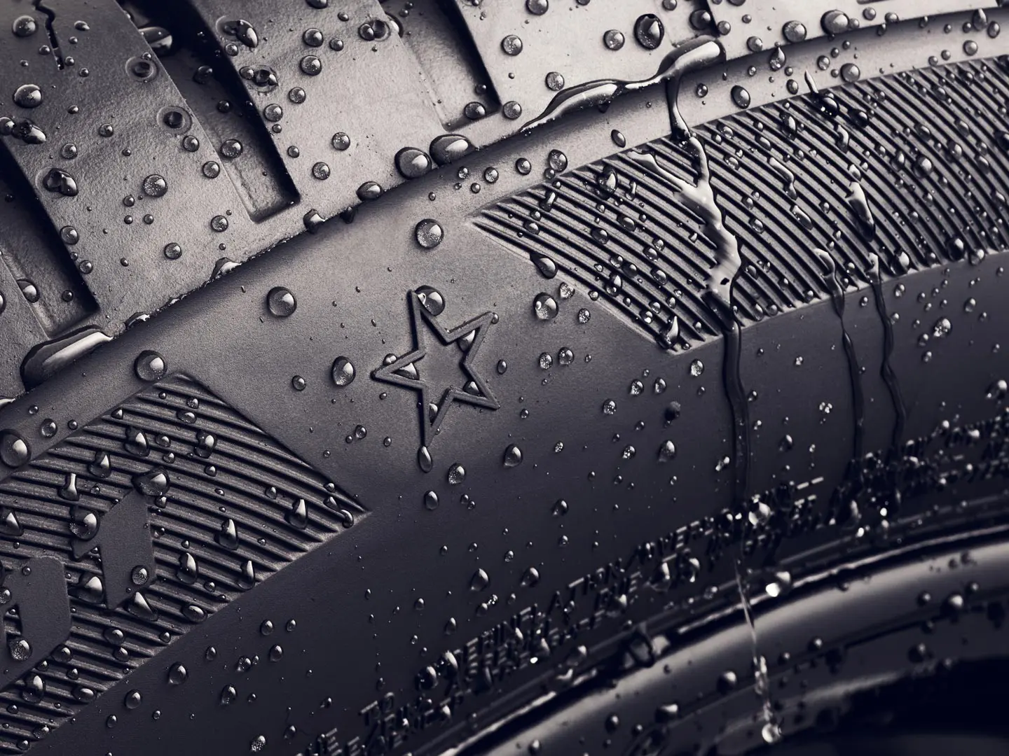 Gros plan sur le flanc d’un pneu portant le symbole de l’étoile, qui indique qu’il est homologué pour des performances optimales sur les véhicules MINI. 