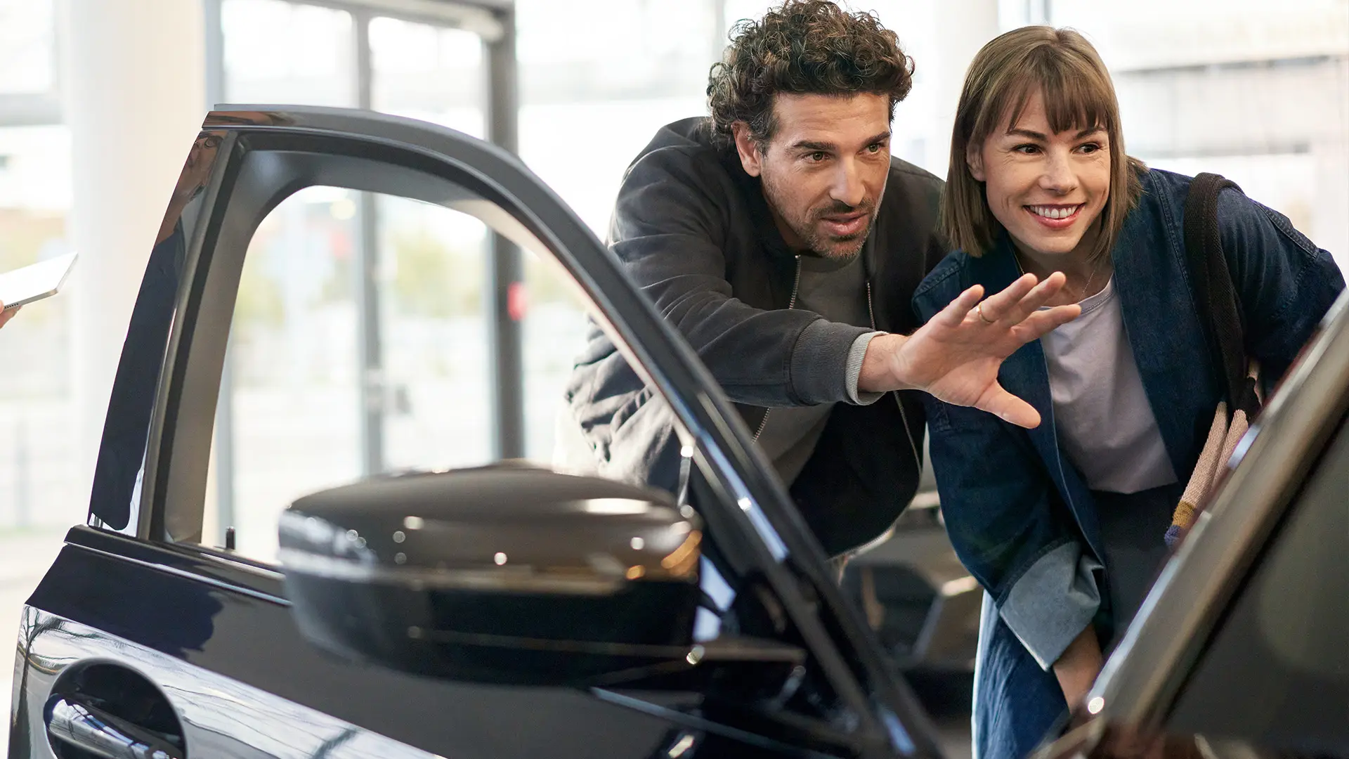 MINI all'interno del MINI Dealership Centre con un consulente che consiglia il cliente e illustra le caratteristiche degli interni.