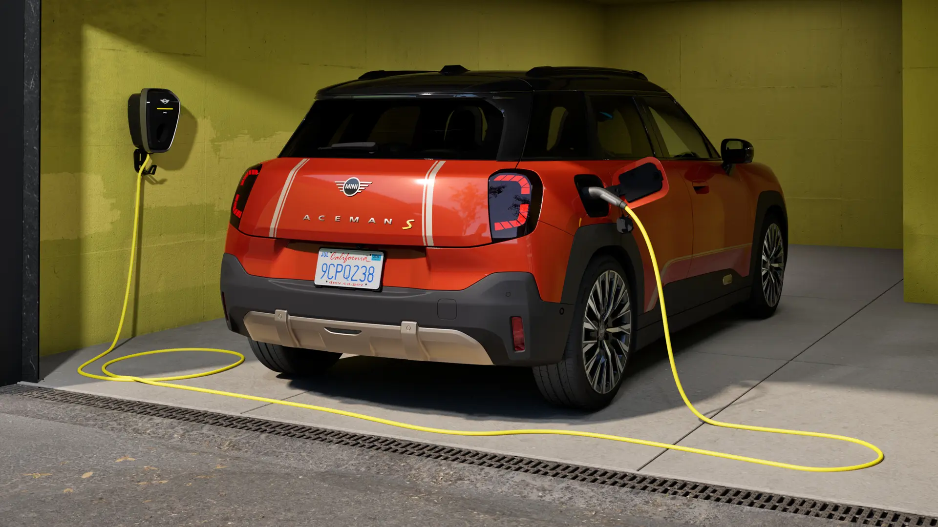 Heckansicht eines vollelektrischen MINI Aceman, der in einer Garage parkiert ist und mit der MINI Wallbox Plus geladen wird.