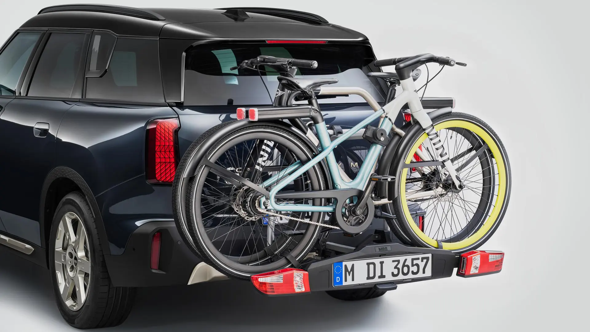 Heckansicht eines MINI Countryman in Schwarz mit Veloheckträger und zwei Mountainbikes.
