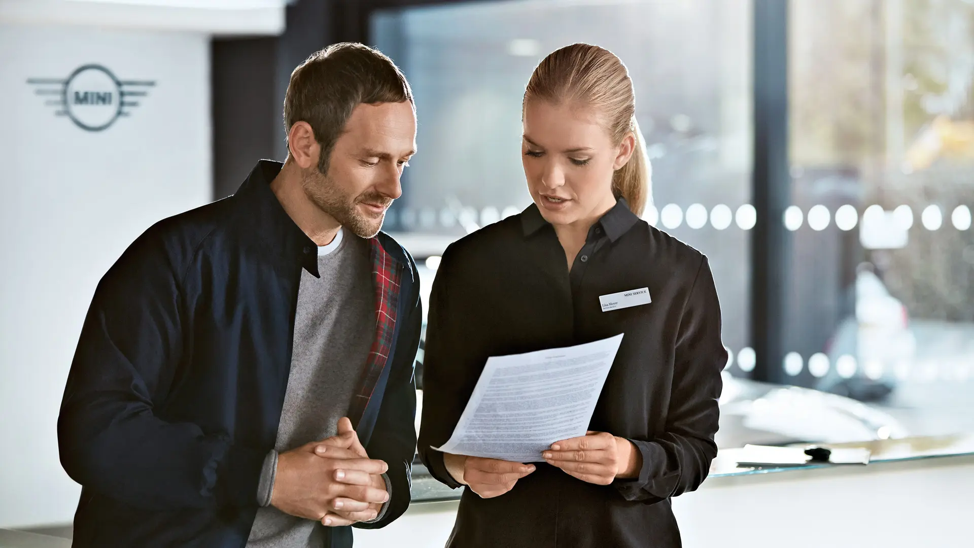 Consulente MINI Service che consiglia un cliente sui piani di assistenza presso un centro MINI.