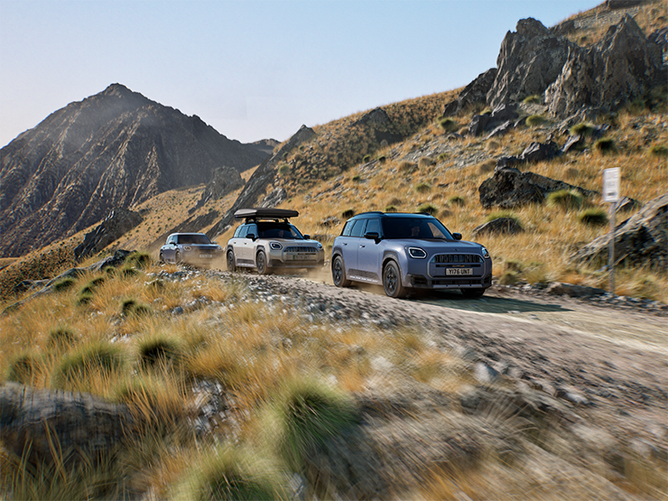 Bild von mehreren MINI Countryman Untamed Edition-Modellen, die auf einer Bergstrasse im Gelände fahren
