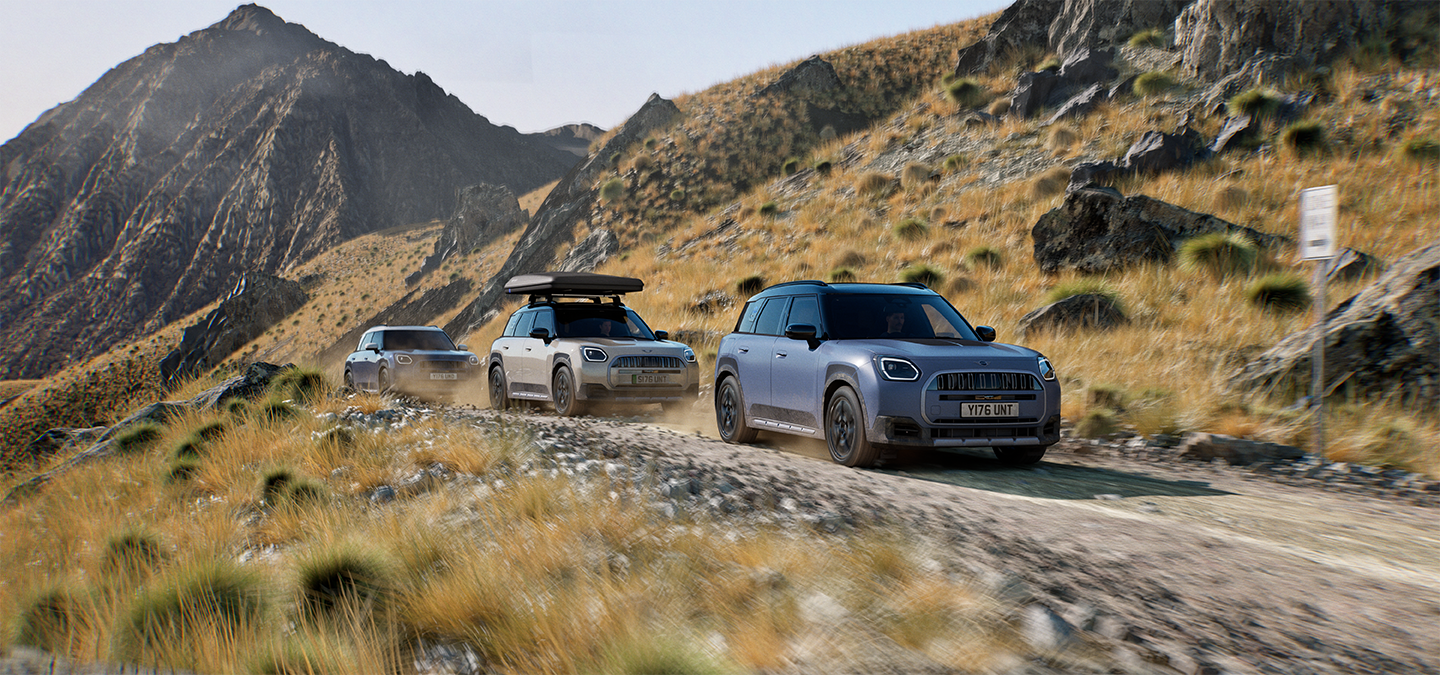 Bild von mehreren MINI Countryman Untamed Edition-Modellen, die auf einer Bergstrasse im Gelände fahren