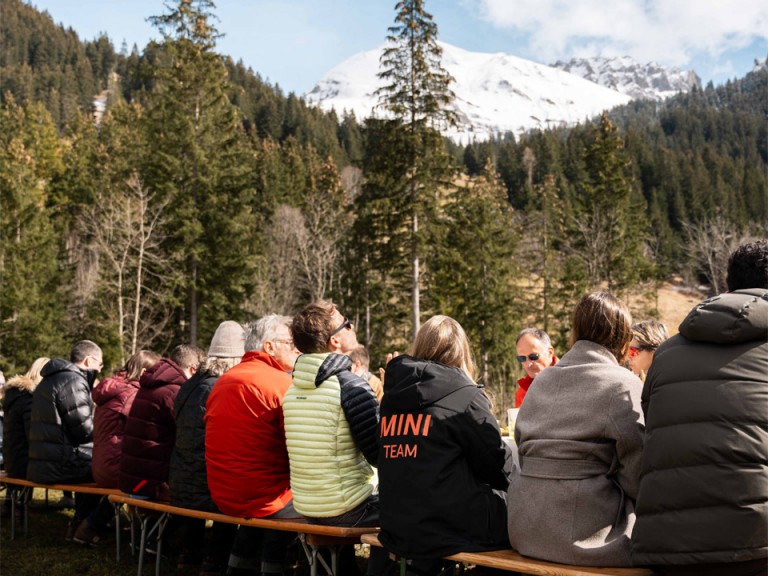 People sitting on benches in cold mountain setting