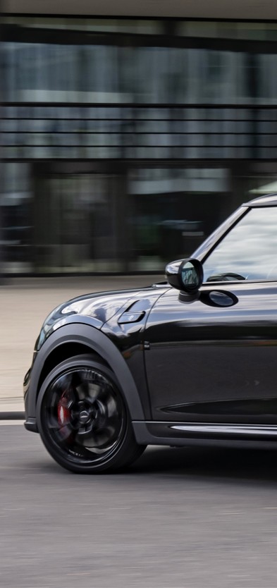 MINI JCW Seitenansicht fahrend vor Gebäude