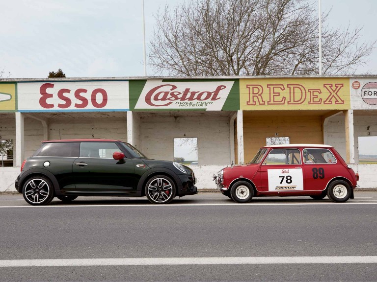 Modello MINI Heritage davanti alla MINI John Cooper Works 3 door ferme in un parcheggio.jpg